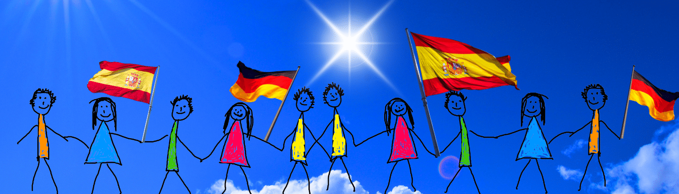 Kinder mit deutschen und spanischen Flaggen vor blauem Himmel